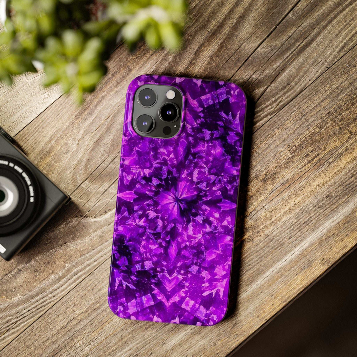 Purple kaleidoscope iPhone case on wooden surface with camera and flash cutouts