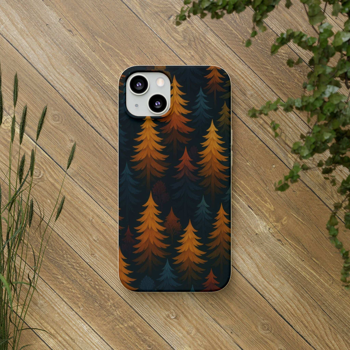 Biodegradable phone case with dark pine tree pattern in orange and teal; camera cutouts