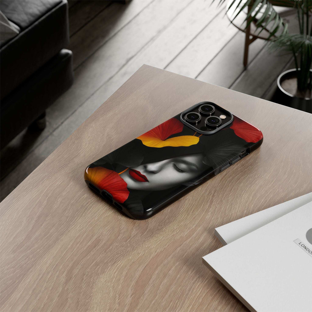 Glossy phone case with red and yellow flowers over a black woman face print.