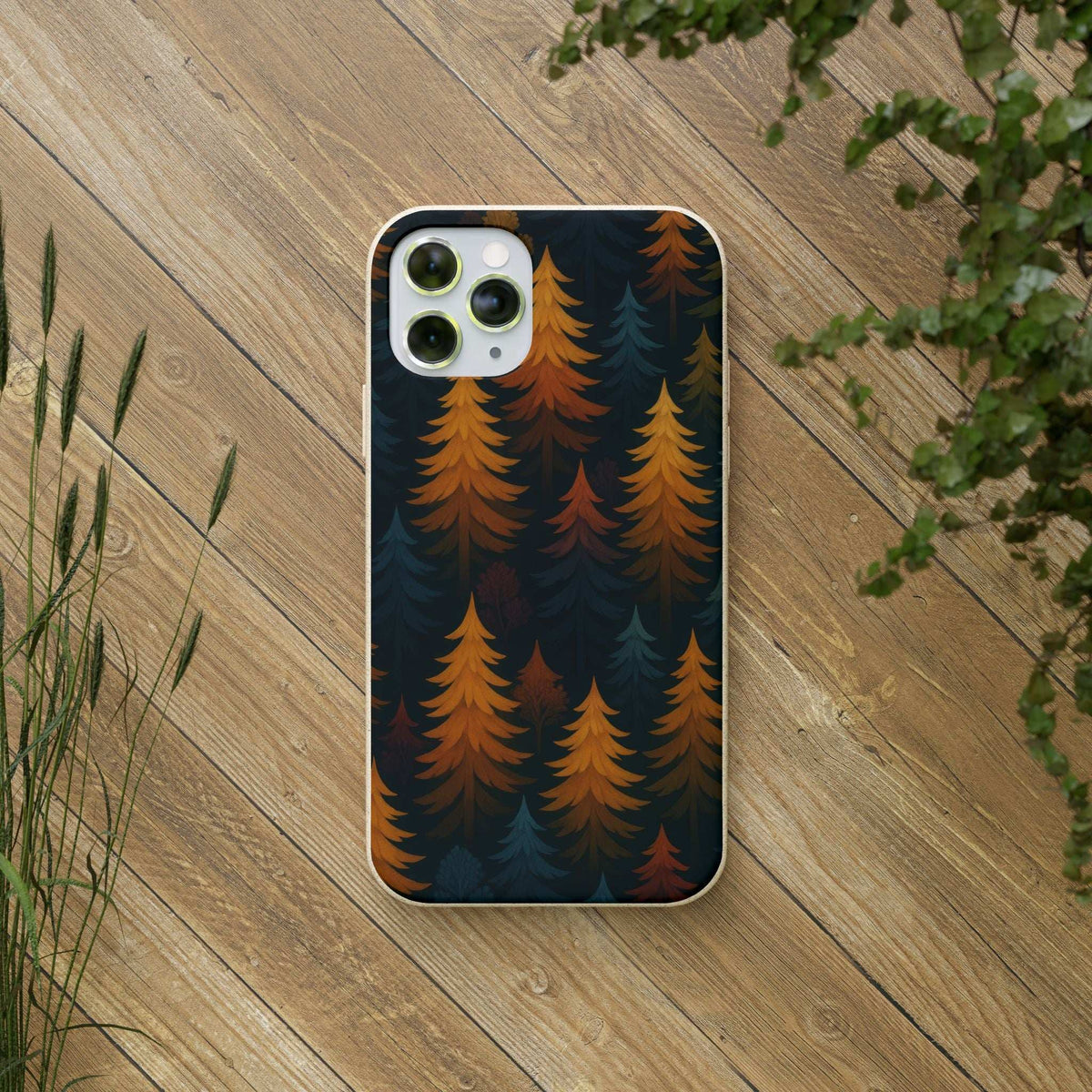 Biodegradable phone case with forest trees pattern, dark blue and orange, on a phone