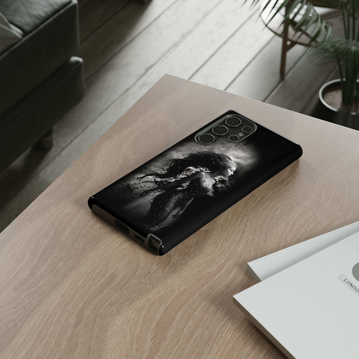 Black monochrome mermaid phone case lying flat with side button openings visible