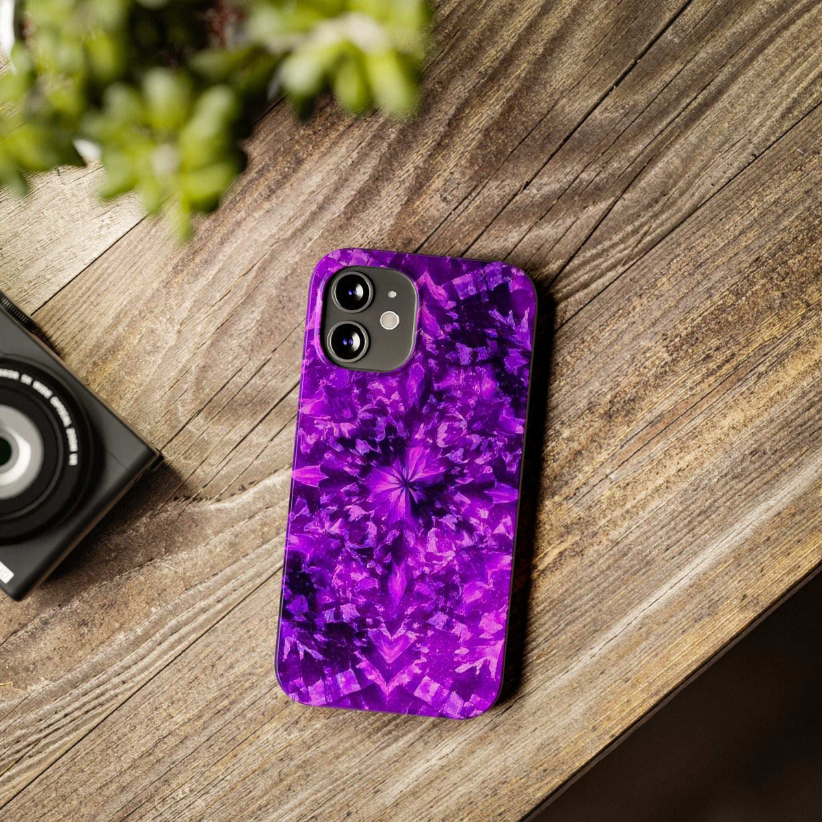 Purple kaleidoscope iPhone case shown on wood, camera cutouts visible