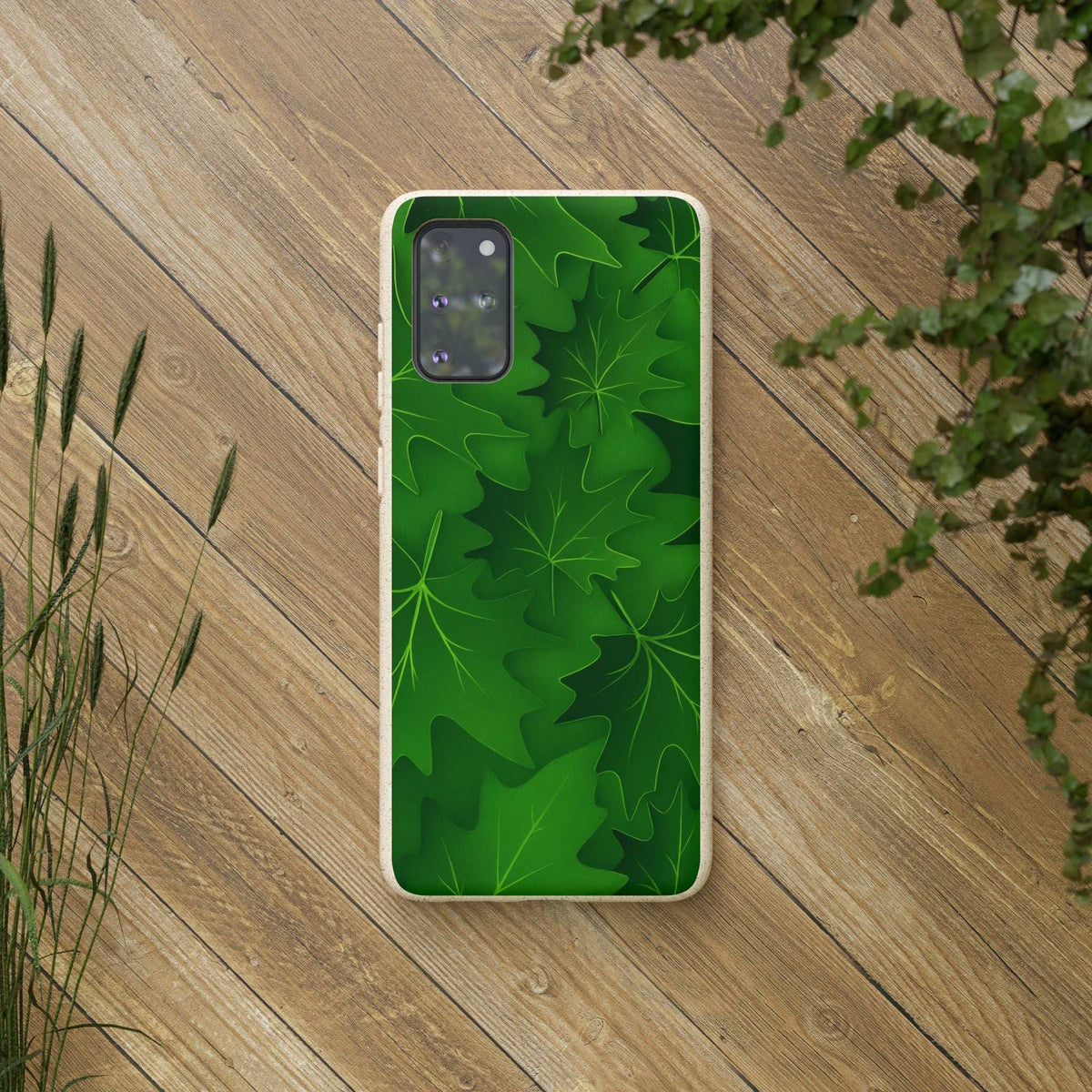 Green botanical leaf phone case on wooden surface with camera cutouts visible.