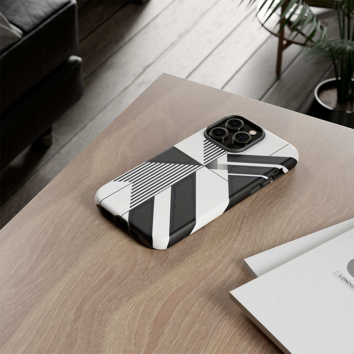 Monochrome tough phone case with black-and-white geometric stripes on a tabletop
