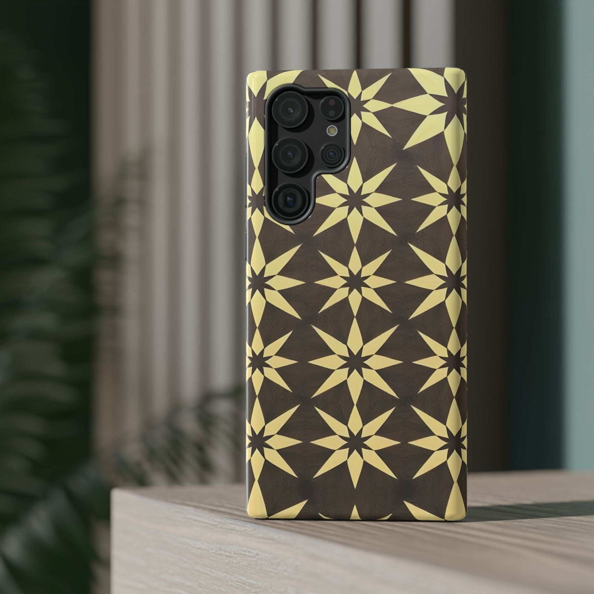 Phone case with gold starburst geometric pattern on dark base and front camera cutout