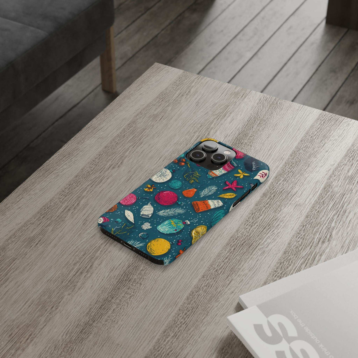 Teal winter phone case on tabletop with colorful ornament and starfish pattern