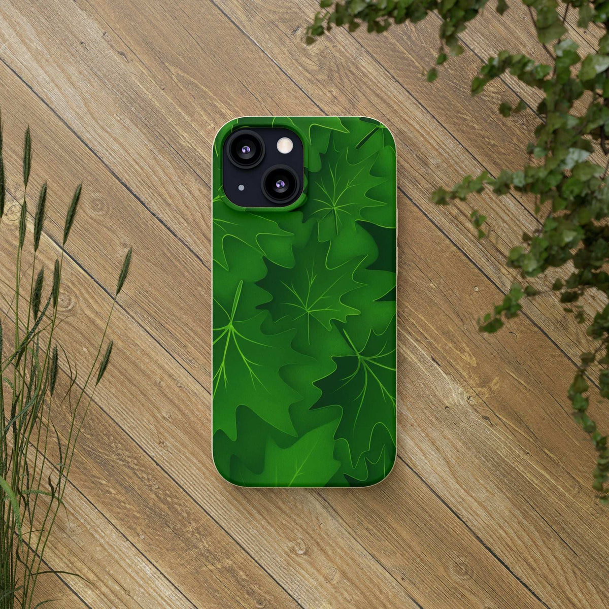 Green leaf patterned phone case on wooden surface, camera cutout visible