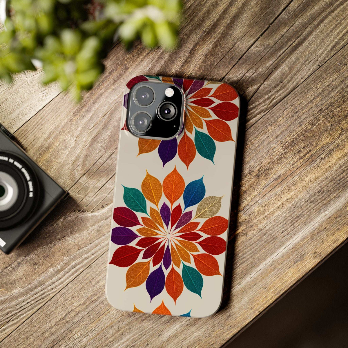 Leaf mandala phone case on wood with multicolor leaves and camera lens openings