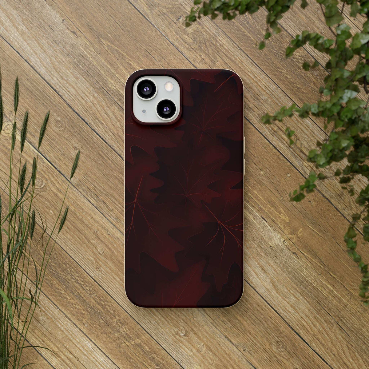 Phone case with dark red leaf pattern and dual camera cutouts
