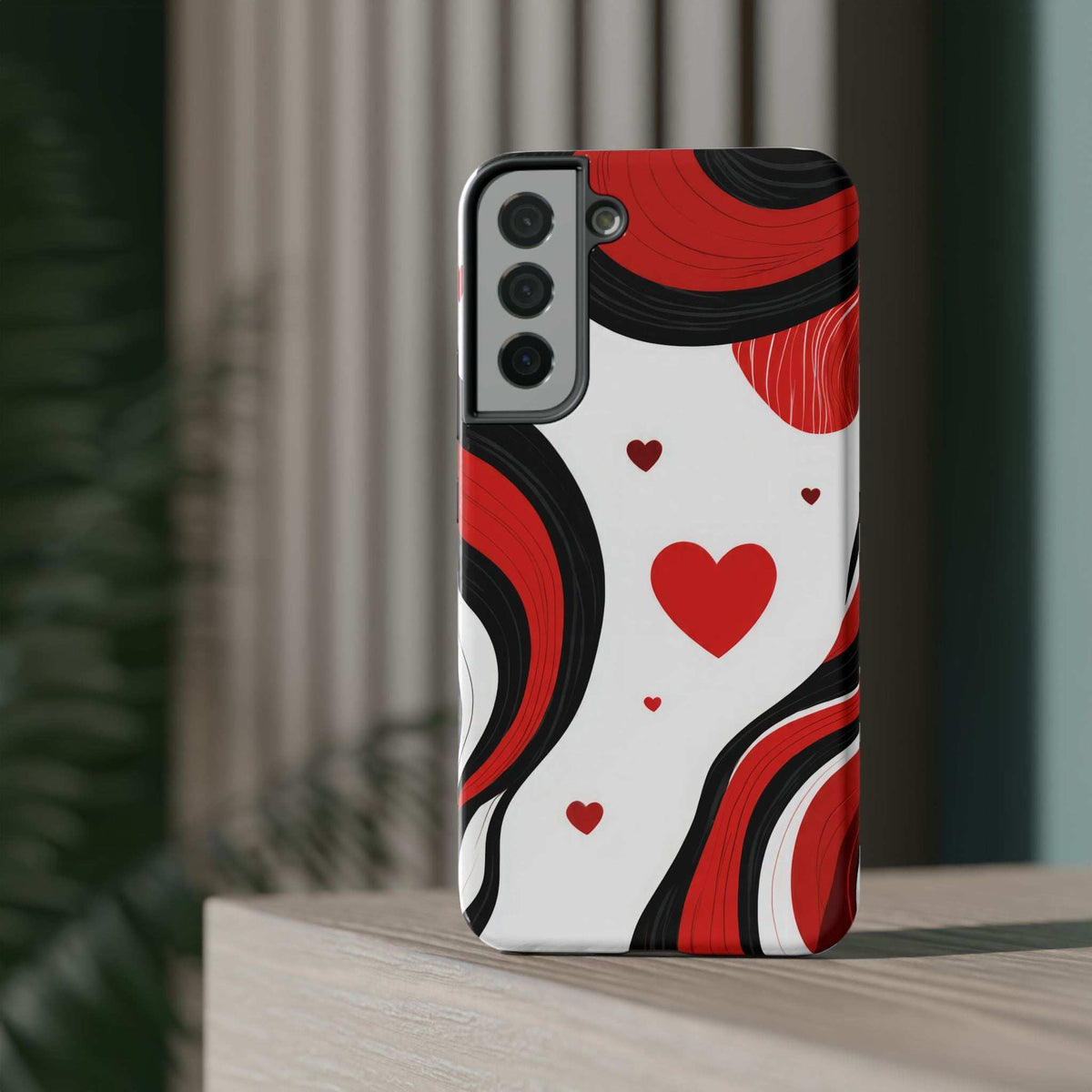 Upright back view of red, black, and white swirl heart phone case with camera cutouts