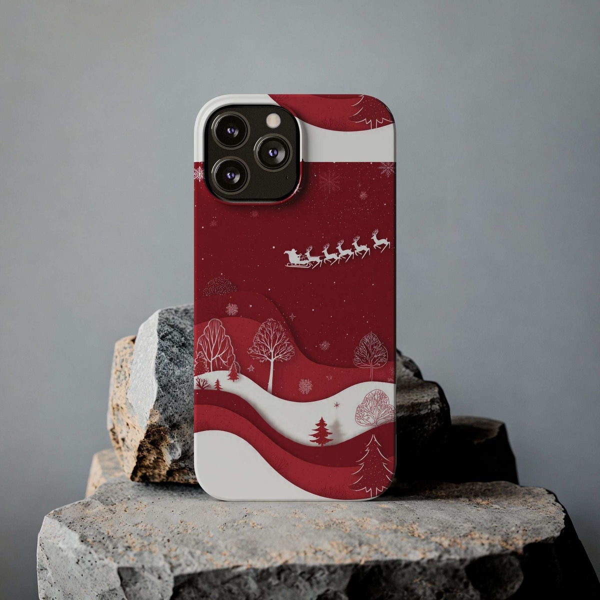 Festive winter phone case in red with snowy hills, trees, and sleigh scene on the front.