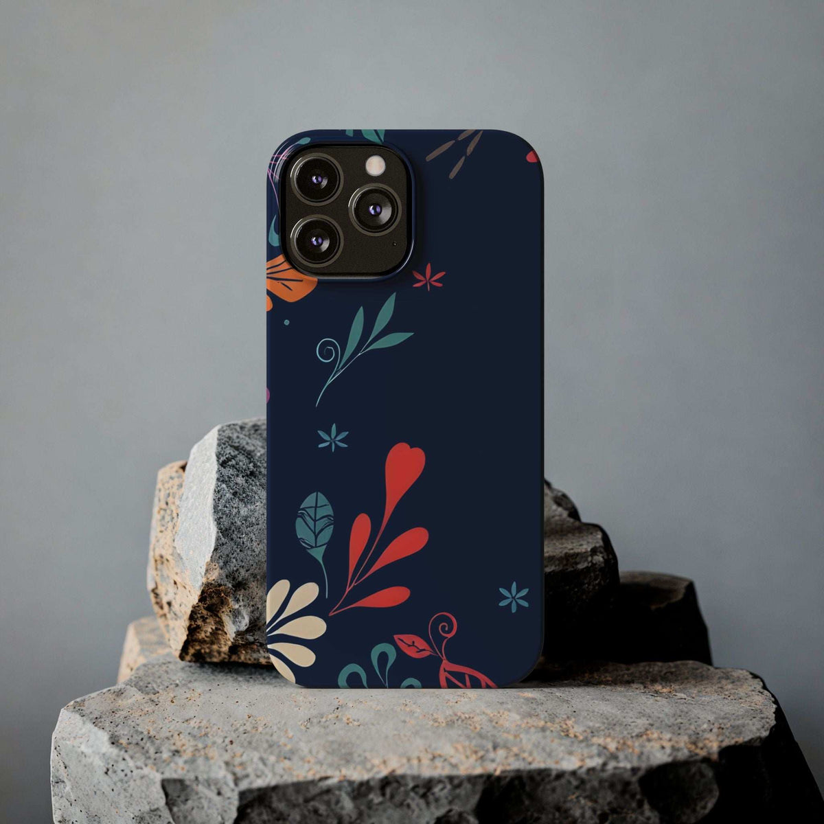 Dark navy floral phone case with red heart, leaves, and teal sprig accent marks