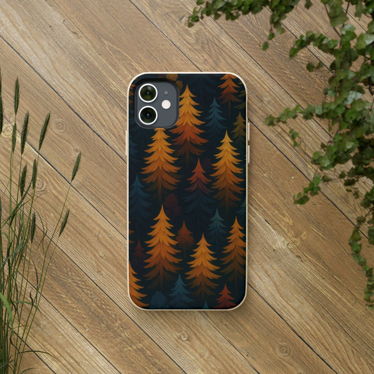 Biodegradable phone case with forest trees pattern, dark blue and orange, on a phone