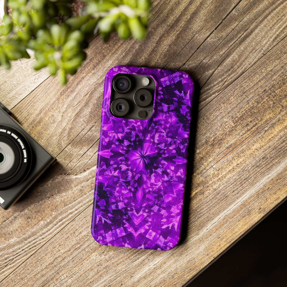 Purple kaleidoscope phone case on wood with camera cutouts and vivid glossy pattern.