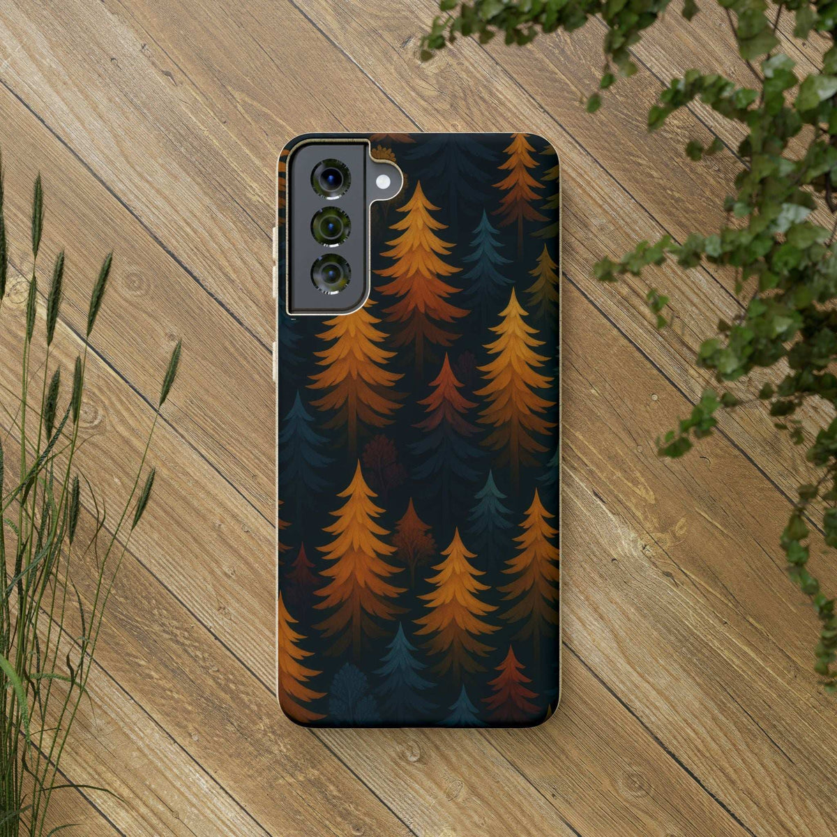Biodegradable phone case back with dark forest trees pattern in orange and teal