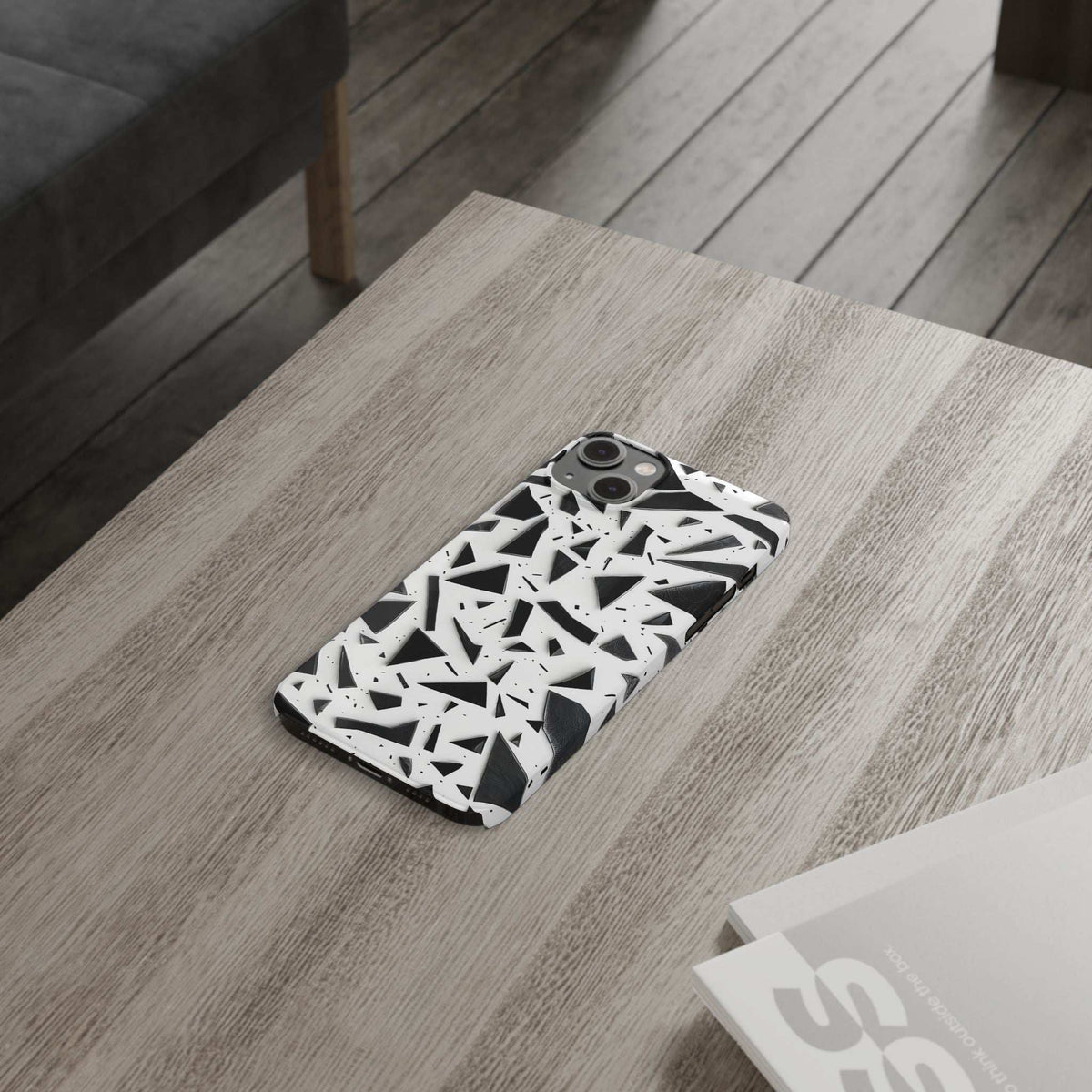 Slim iPhone phone case on surface, white abstract black geometric pattern, rear camera visible.